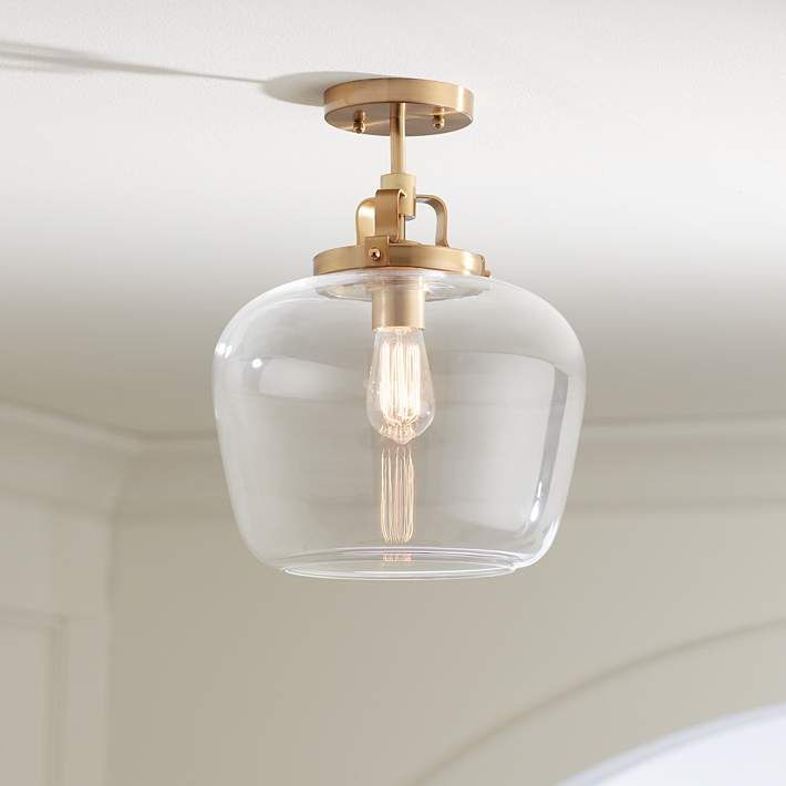 a clear glass light fixture hanging from a ceiling in a room with white walls and ceilings