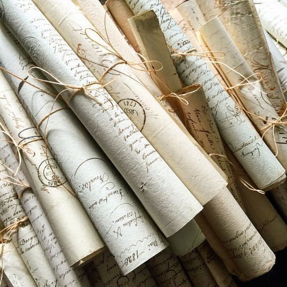 many rolled up papers with writing on them are lined up in a row and tied together