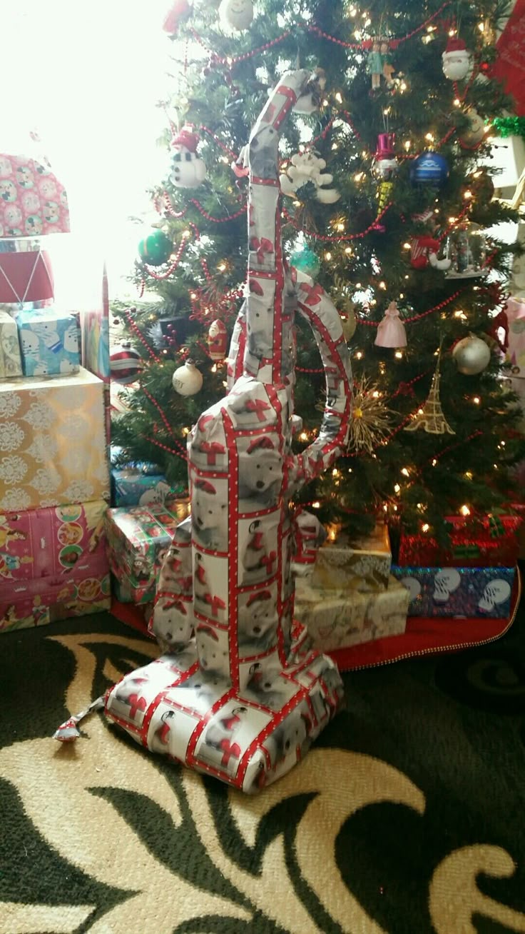 a christmas tree with presents under it and a gift bag on the ground in front of it