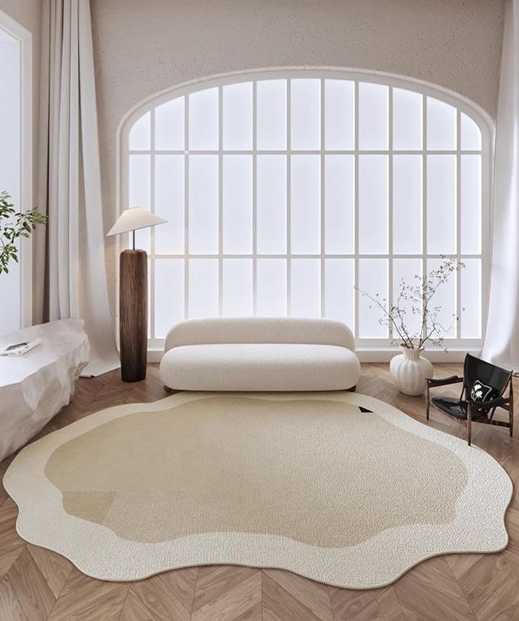 a living room with a white couch and large round rug in front of a window