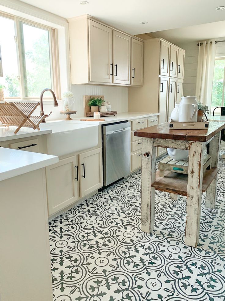 a kitchen with an island in the middle of it and lots of cabinets on both sides