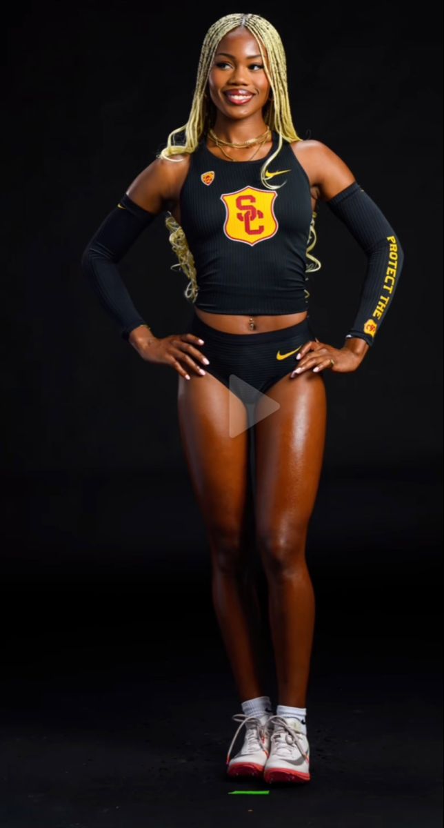 a woman posing for the camera in a black sports bra top and shorts with her hands on her hips