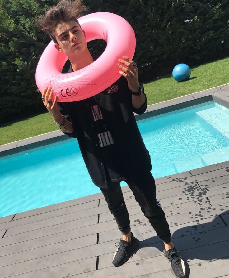 a man holding an inflatable ring near a swimming pool