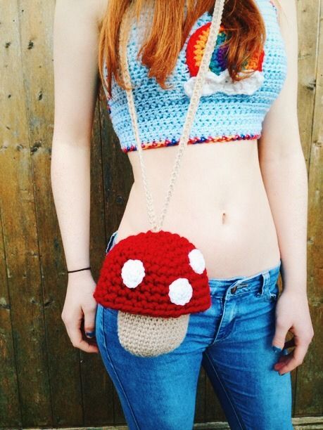 a woman wearing a crocheted bag with a mushroom on it