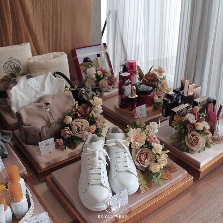 three trays with flowers and shoes on them in front of a window next to other items