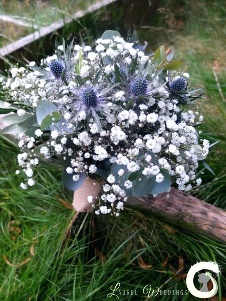 a bouquet of white flowers sitting on top of a wooden stick in the middle of some grass