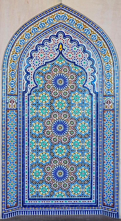 an ornate window with blue and green tiles on the side of a building in morocco