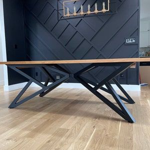 a wooden table sitting on top of a hard wood floor next to a black wall