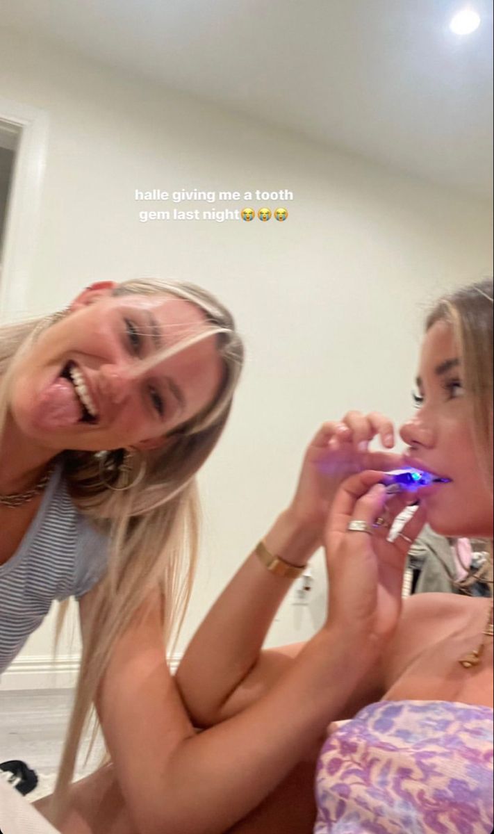 two beautiful young women brushing their teeth together