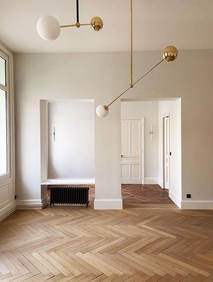 an empty room with wood flooring and white walls in the background is a radiator