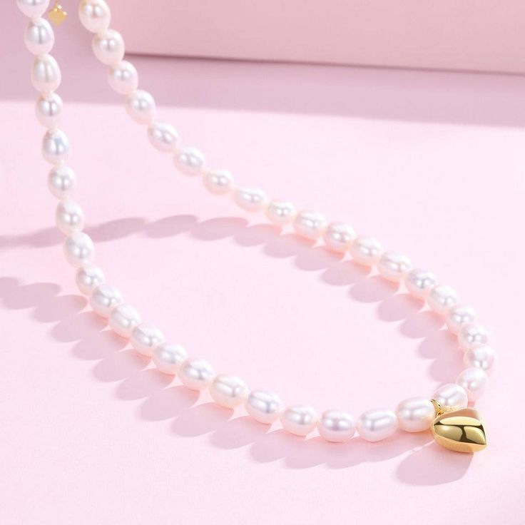 Adorn a youthful vibe with our 5-6mm Oval Rice Pearl Necklace, featuring a charming heart pendant. Ideal for those who love playful and lively styles, this necklace showcases high-luster freshwater pearls in an oval rice shape. It extends from 40cm to 45cm with an adjustable silver extension chain, making it versatile and suitable for any look. Product Details: Pearl Type: Freshwater Rice Pearls Pearl Size: 5-6mm Shape: Oval (Rice) Luster: High Pendant: Heart-shaped Length: 40cm + 5cm Extension Classic White Necklace With Heart Charm, Pearl White Oval Beads Pearl Necklace For Gift, Pearl White Pearl Necklace With Oval Beads For Gift, Pearl White Necklace With Oval Beads For Gift, White Pearl Drop Necklace For Valentine's Day, White Pearl Heart Pendant Necklace, White Heart-shaped Pearl Pendant Necklace, White Pearl Heart Necklace With Charm, White Pearl Necklace With Heart Charm