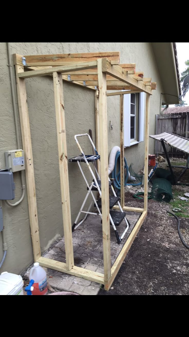 an outdoor shower is built into the side of a house with wood framing around it