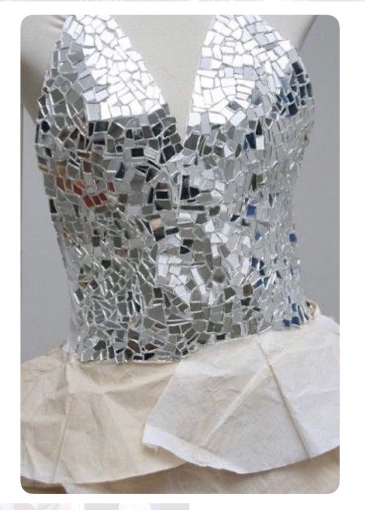 a mannequin made out of silver and white tiles on top of a dress