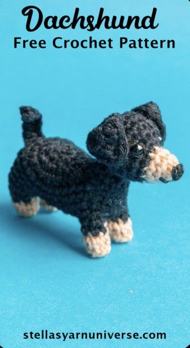 a crocheted black and tan dog on a blue background