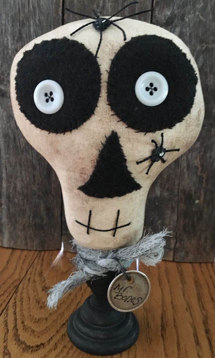 a stuffed skull with two eyes on top of a wooden table