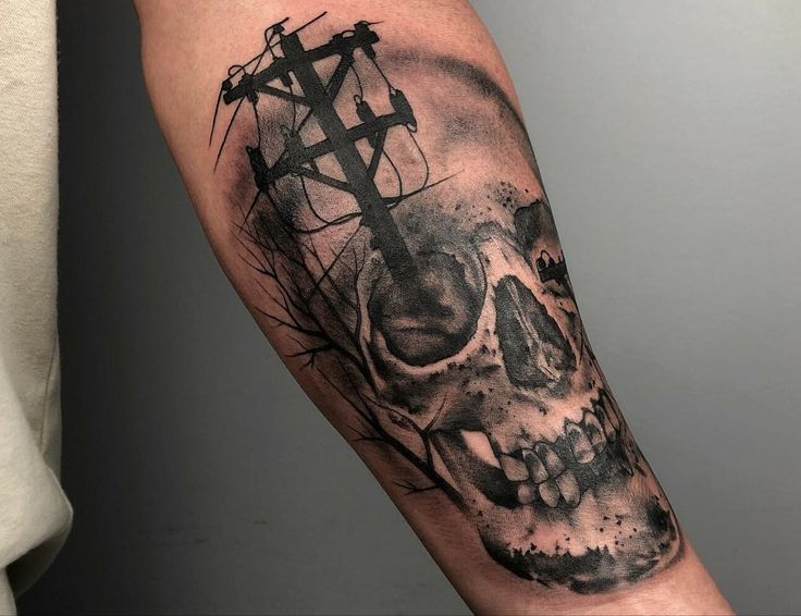 a man's arm with a skull and cross tattoo on it