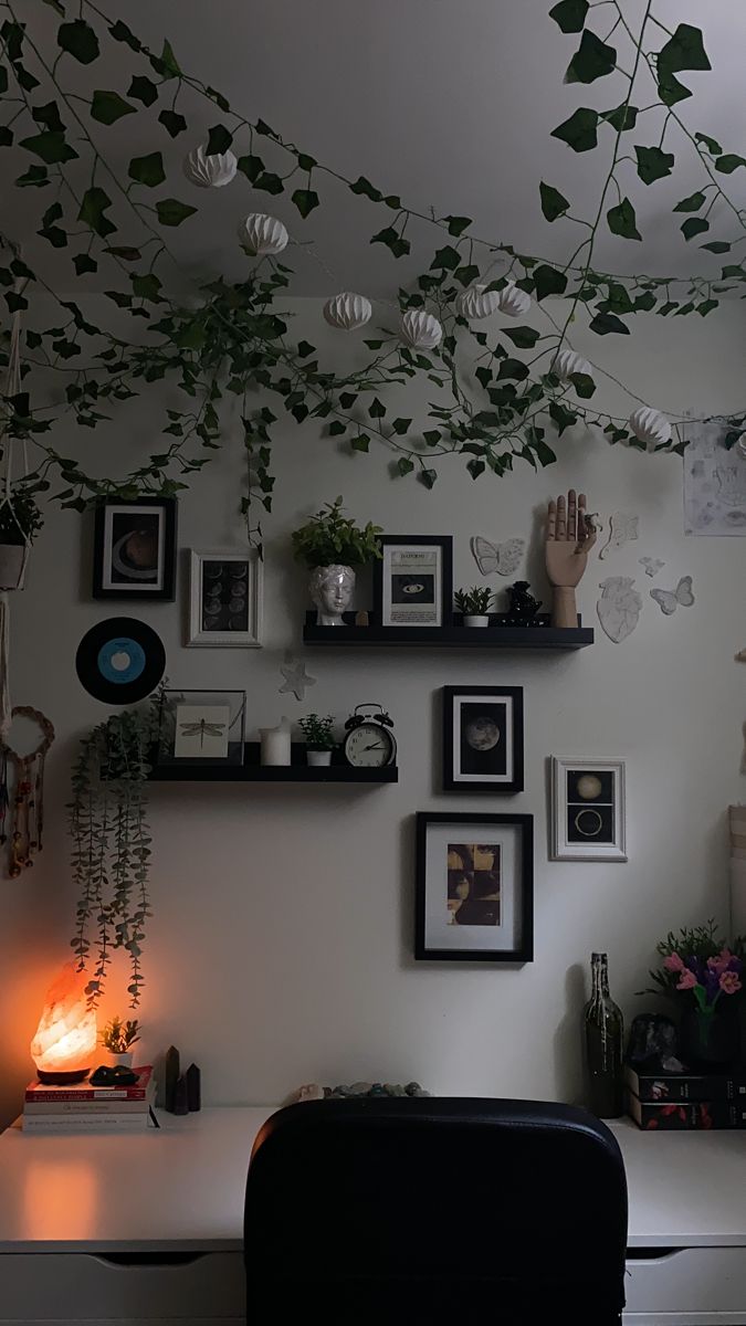 a living room filled with lots of plants and pictures hanging on the wall next to a chair