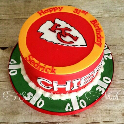 a birthday cake decorated with the kansas chiefs logo and name on it is sitting on a wooden table