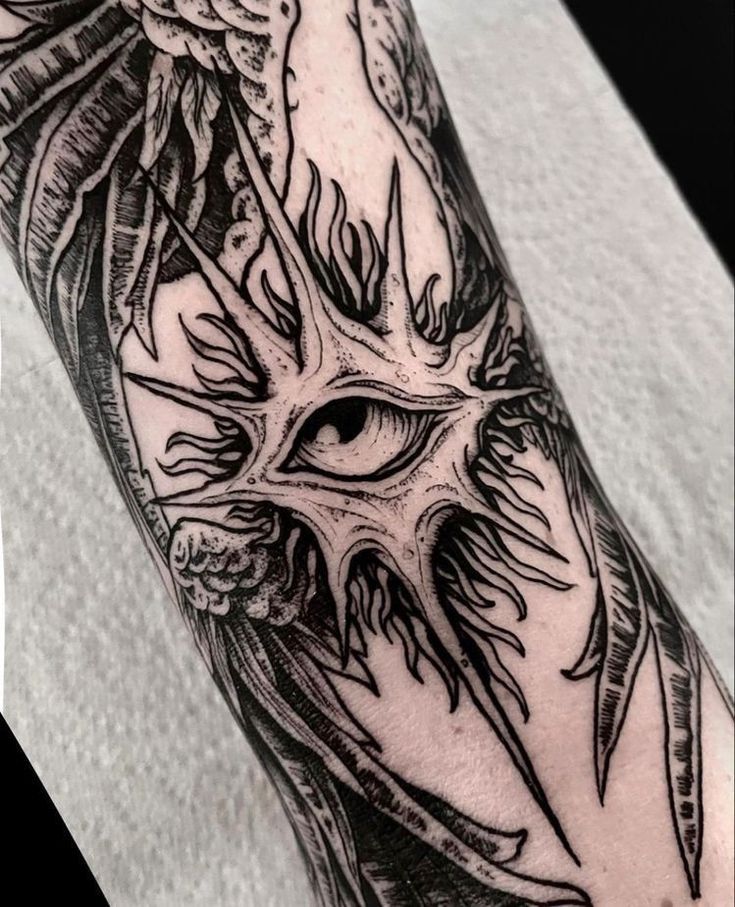 a black and white photo of a tattoo with an eye in the middle of it