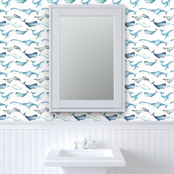 a white sink sitting under a bathroom mirror next to a wall mounted faucet