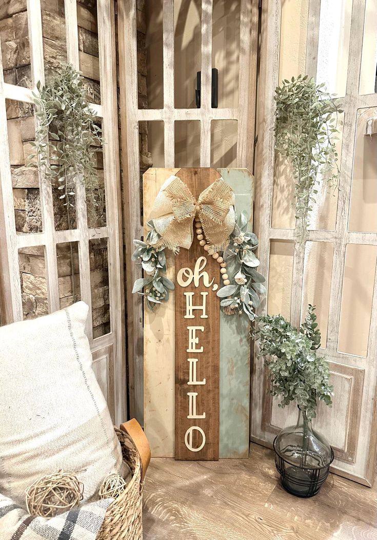 a wooden sign with the words oh hello written on it next to some potted plants