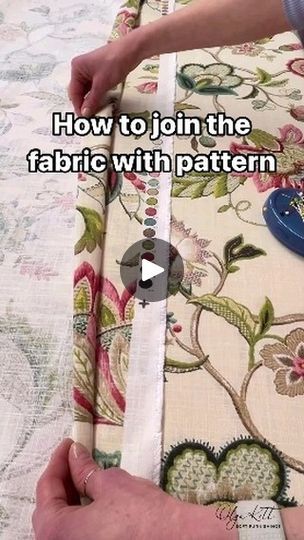 someone cutting fabric with a sewing machine on top of a tablecloth covered in flowers