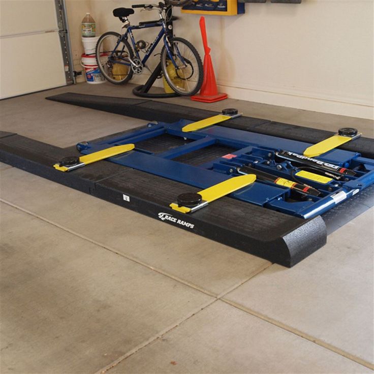 a bike is parked in the garage next to an exercise mat that has been placed on the floor