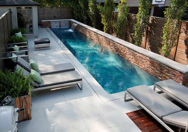 an outdoor pool with lounge chairs next to it