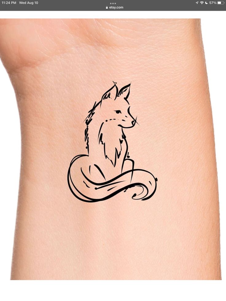 a small tattoo on the back of a woman's arm with a fox sitting in it