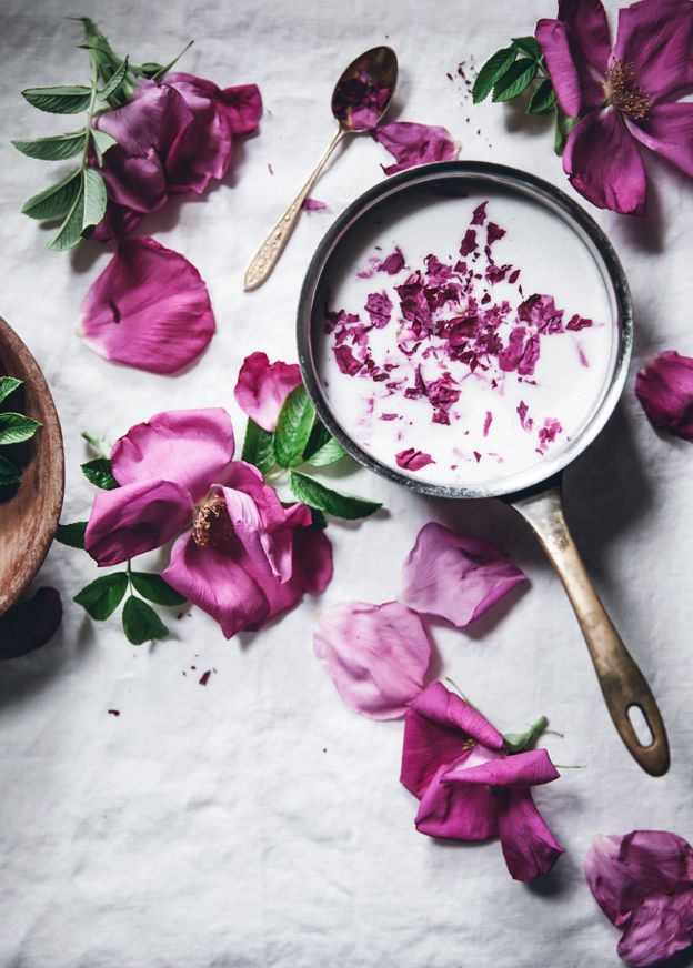 pink flowers and spoons on a white surface