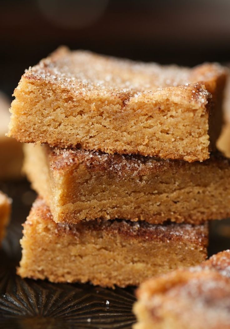 several pieces of cake sitting on top of a glass plate with powdered sugar toppings