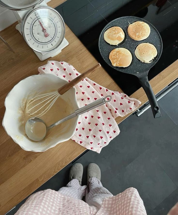 pancakes being whisked in a skillet on top of a counter next to a scale