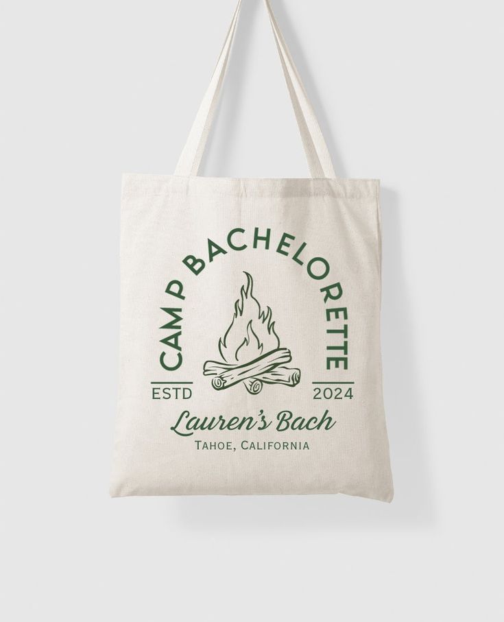 the camp bachelore tote bag is hanging from a hook on a white wall