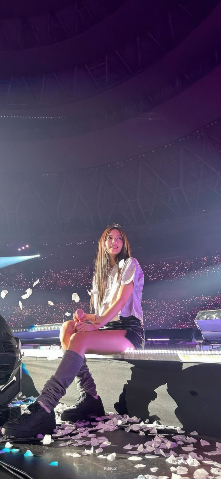 a woman sitting on top of a bench in front of a car and confetti