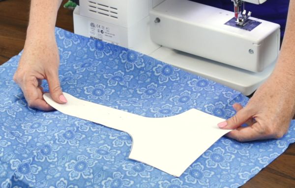 a person is using a sewing machine to sew something on a sheet of paper