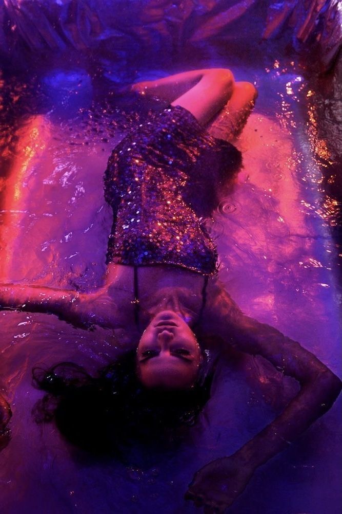 a woman laying on top of a purple surface