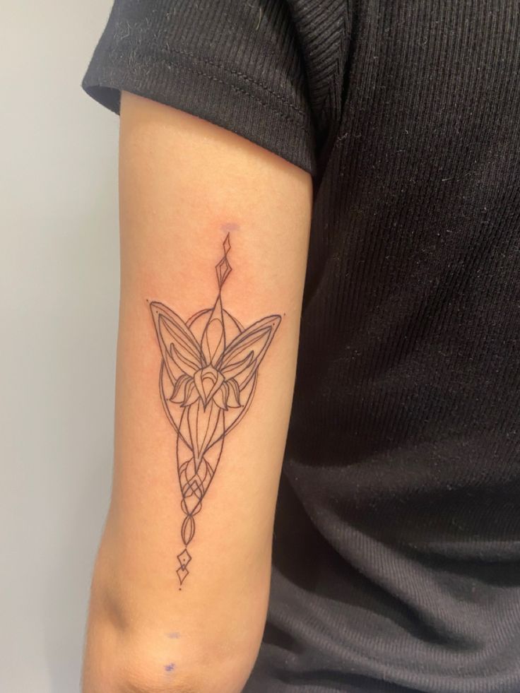 a woman's arm with a geometric tattoo design on the back of her left arm