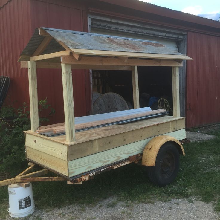 an old truck with a bed on the back is parked in front of a red building