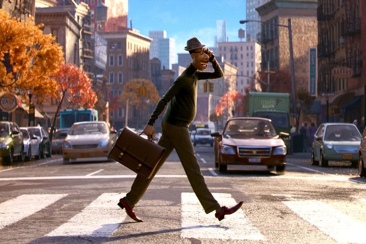 a man walking across a street holding a briefcase and talking on a cell phone,