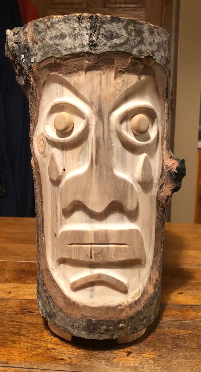 a wooden mask sitting on top of a table