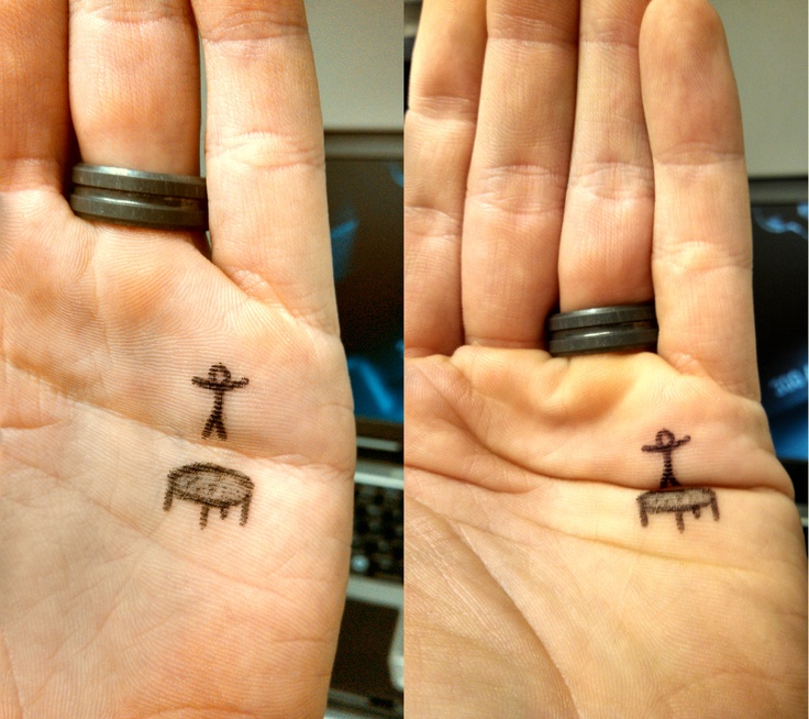 two small tattoos on the palm of someone's hand, depicting sheep and crosses