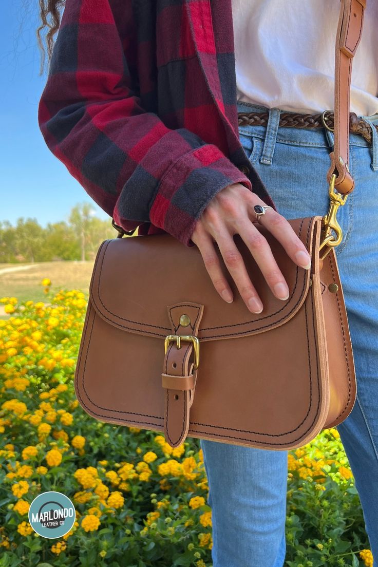 The Marlondo Leather Saddle Crossbody Purse is a vintage inspired saddle bag purse, perfect for weekend adventures and everyday carry. This purse has a belted buckle closure for a timeless chic look. The Saddle Crossbody features an interior pocket and two slot pockets on the bag's exterior: one across the rear of the bag and another just under the main flap. The Saddle Crossbody also comes with an adjustable and removable strap. Timeless Saddle Bag With Adjustable Strap For Everyday, Timeless Everyday Saddle Bag With Adjustable Strap, Timeless Crossbody Shoulder Bag With Brass Hardware, Classic Crossbody Saddle Bag With Detachable Strap, Classic Saddle Shoulder Bag For Daily Use, Timeless Saddle Bag With Adjustable Strap, Classic Saddle Shoulder Bag For Everyday, Timeless Crossbody Bag With Brass Hardware, Everyday Saddle Bag With Detachable Strap