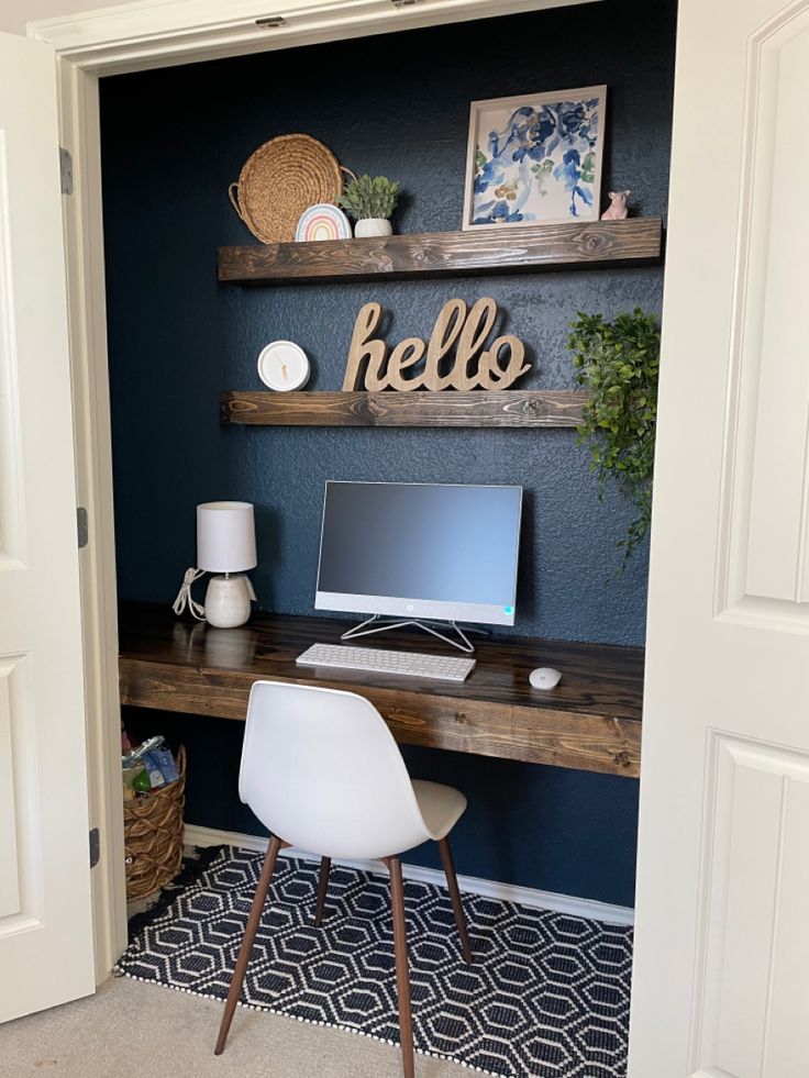 a desk with a computer on top of it in a room that has blue walls