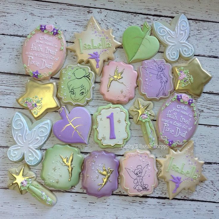 decorated cookies are arranged in the shape of numbers and fairy wands on a wooden table