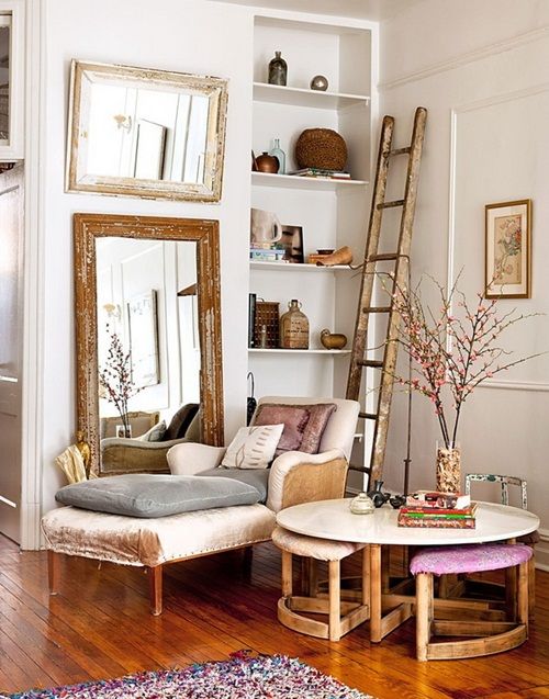 a living room filled with furniture next to a tall wooden ladder in front of a mirror