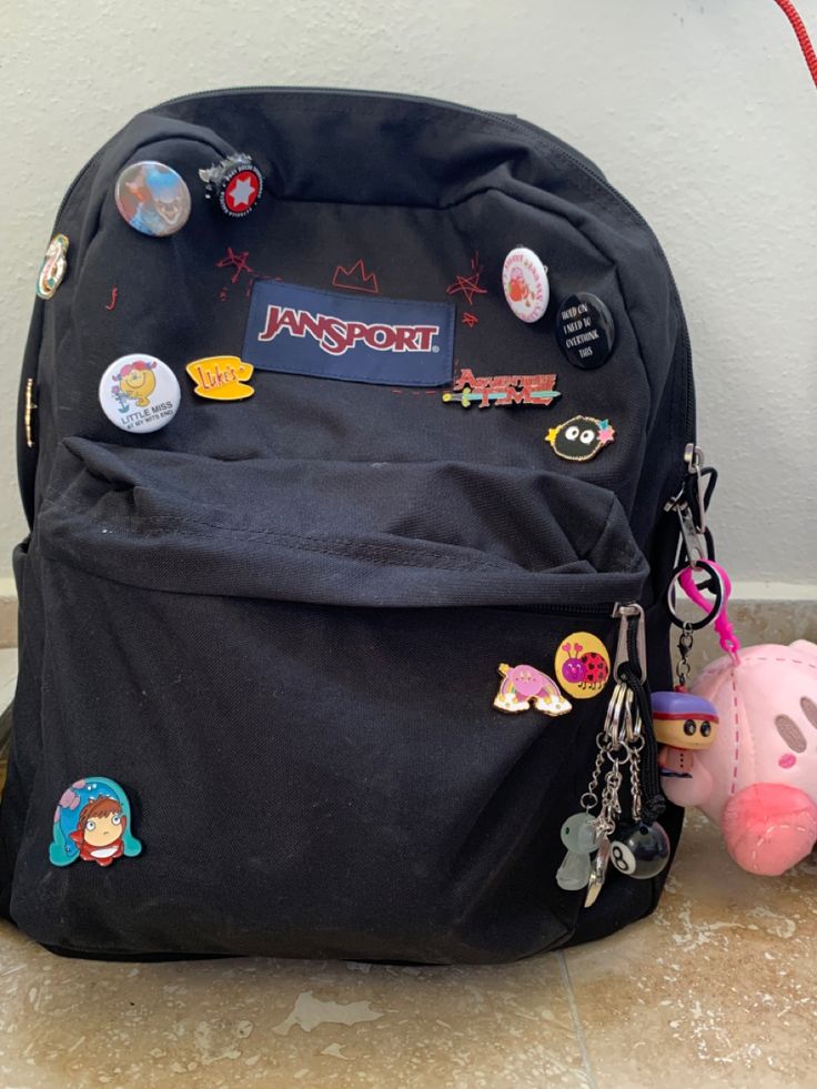 Decorated Jansport Backpack, Jansport Bag With Pins, Jansport Decoration Ideas, Black Backpack With Pins, Bagpack Decorating Ideas, Jansport Bag Aesthetic, Black Jansport Backpacks Aesthetic, Travel Backpack Aesthetic, Black Backpack Aesthetic