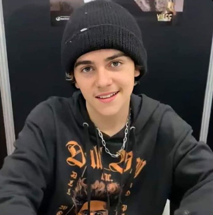 a young man wearing a black beanie and looking at the camera with an intense look on his face