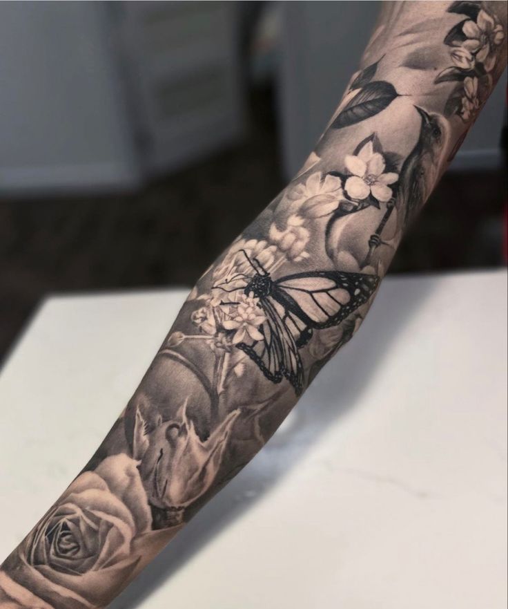 a man's arm with flowers and a butterfly on it