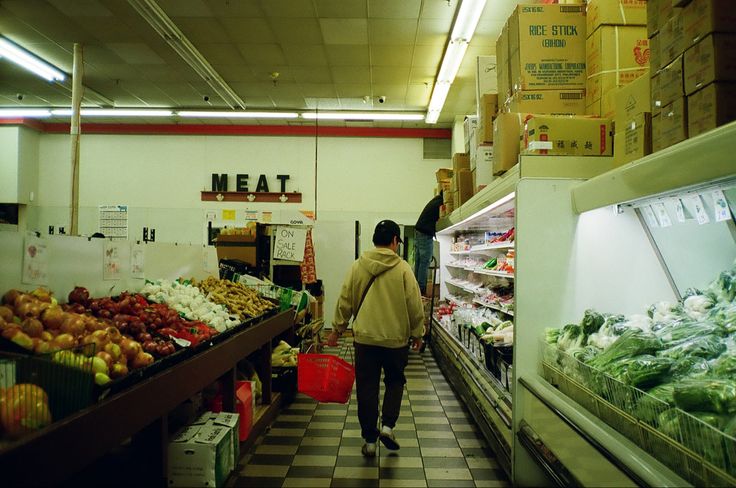 a man is walking down the aisle of a grocery store