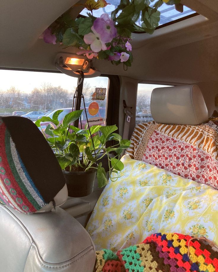 there is a crocheted blanket in the back of a car with pillows and blankets on it